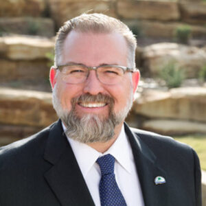 A man with a beard and glasses wearing a suit